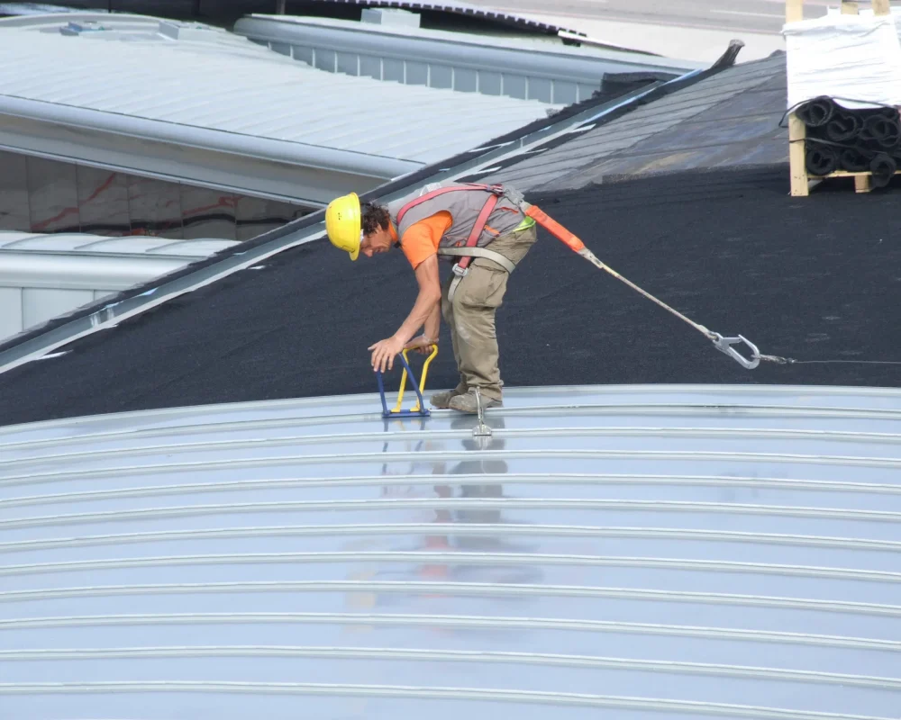 Man applying roof sheets to GEOTEXTILE lining